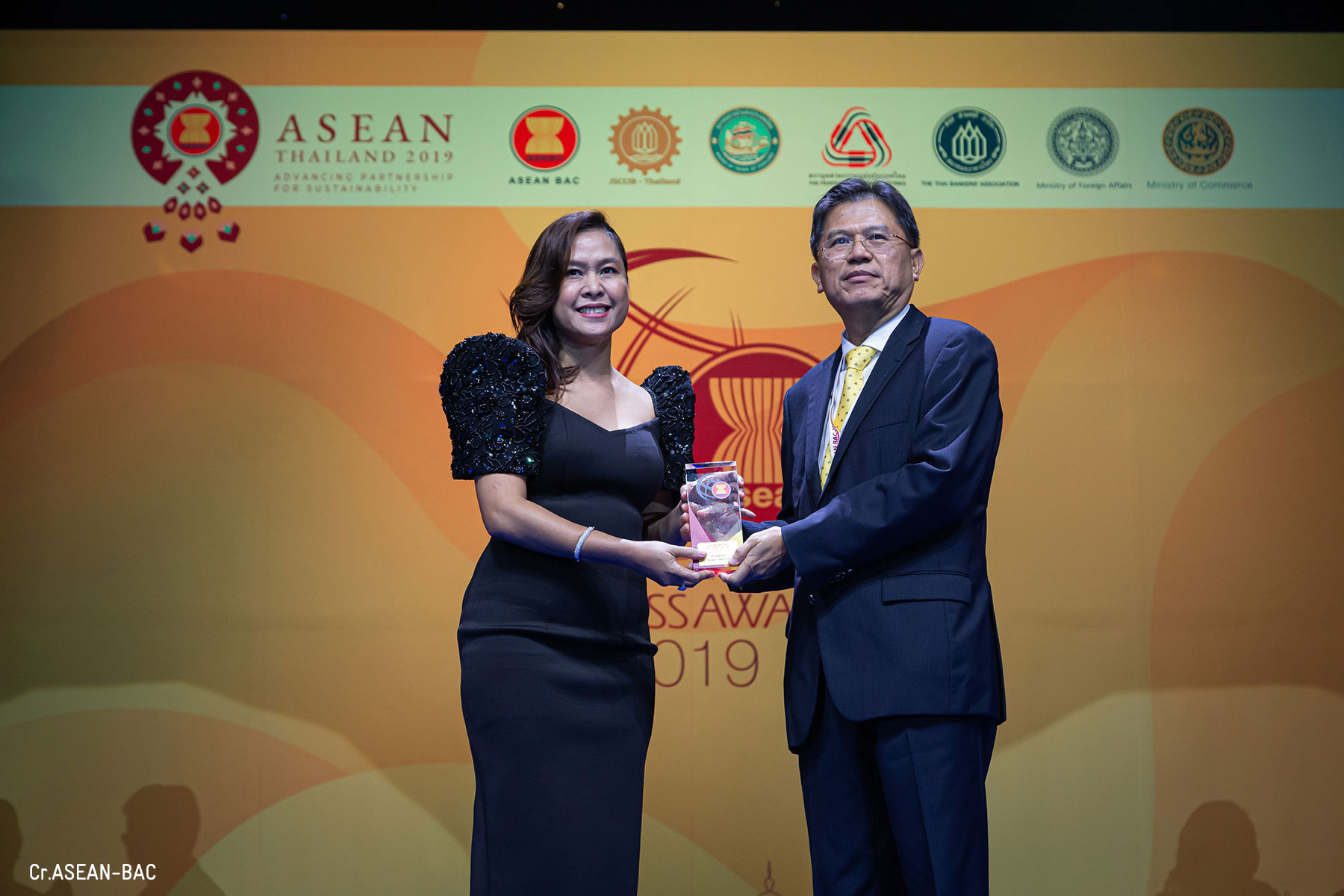 Acuatico receiving the trophy Simonette V. Gusi, General Manager of Acuatico Beach Resort & Hotel and Mr. Predee Daochai, Chairman of the Thai Bankers’ Association